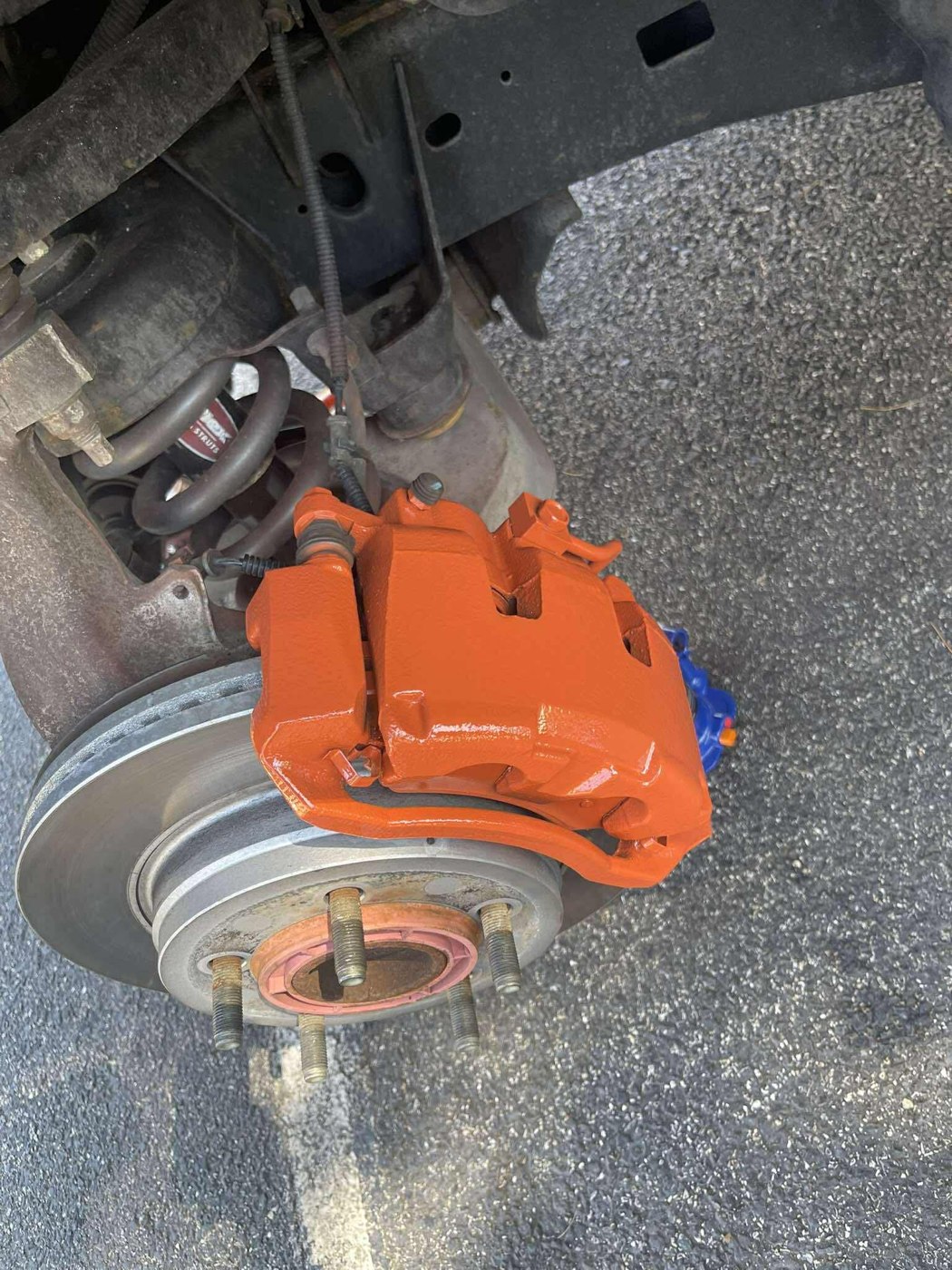 Close-up of a caliper with fresh orange paint